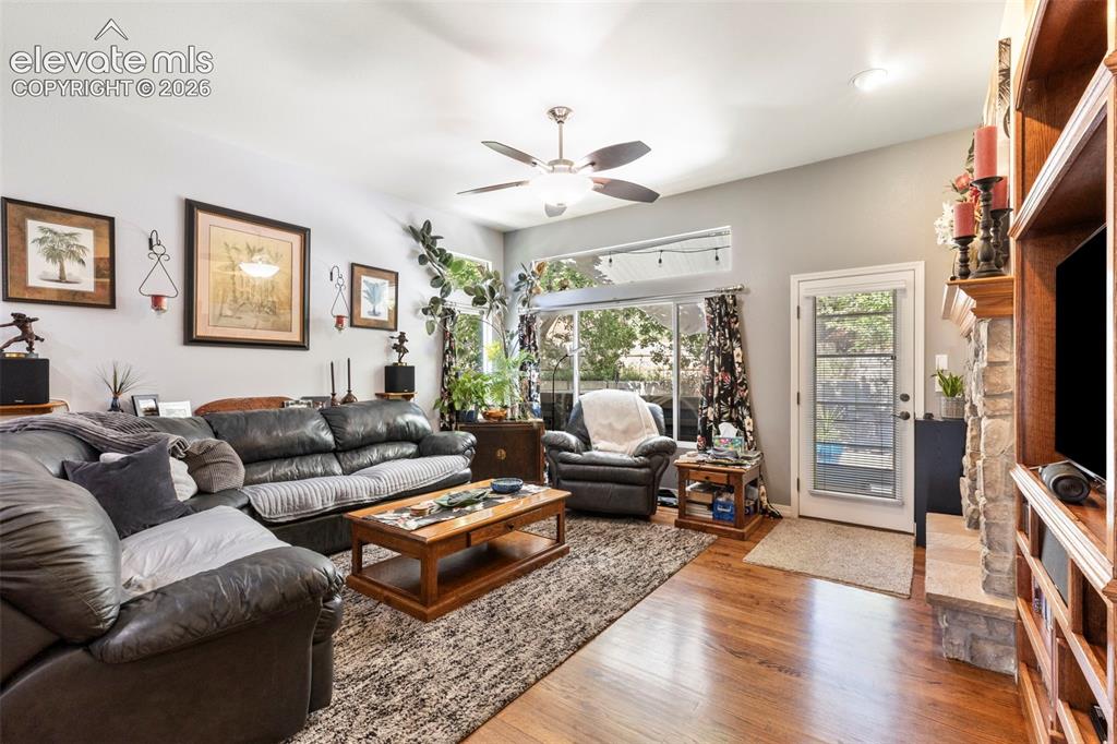 Image 7 of 28: Hardwood flooring throughout, a ceiling fan fixture, a built-in entertainme