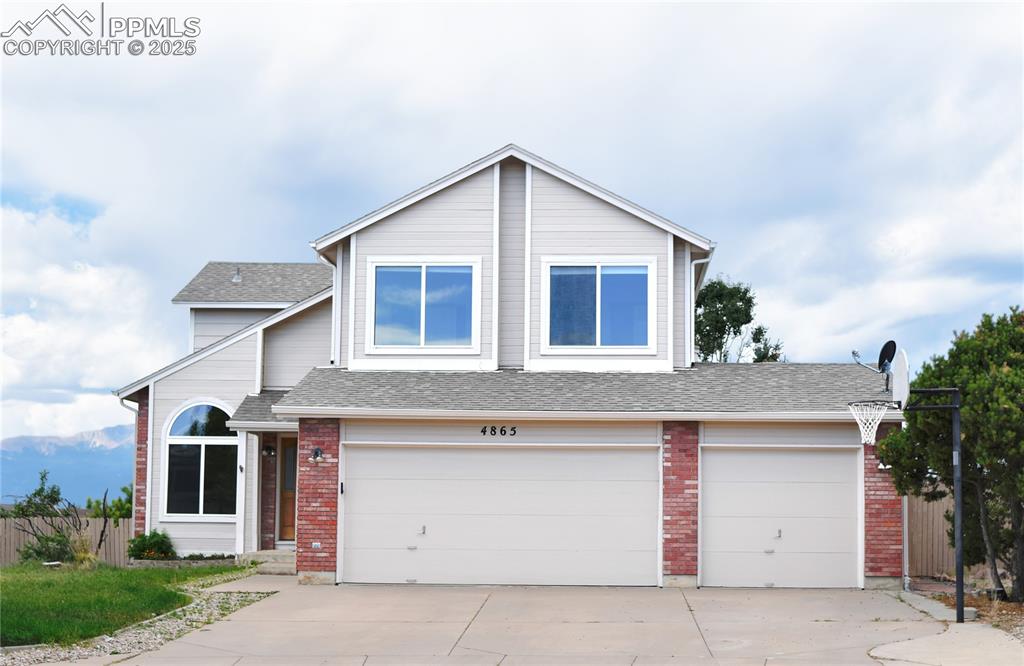 Image 2 of 48: View of front of house featuring concrete driveway, a shingled roof, and br