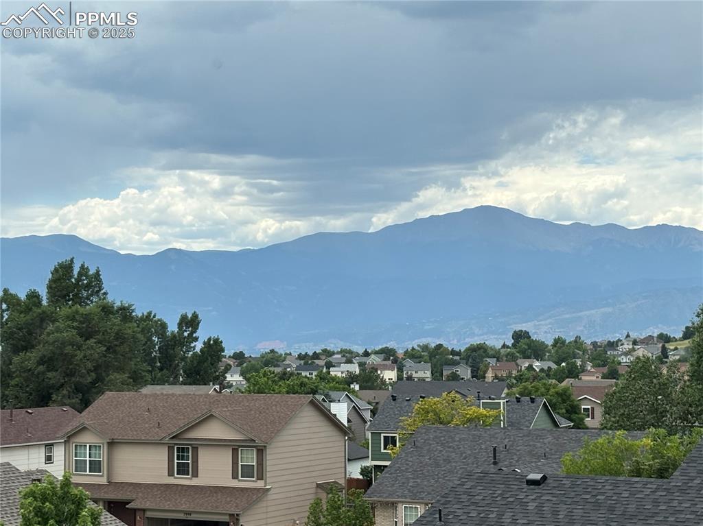 Image 34 of 48: View of mountain from primary bedroom background with nearby suburban area