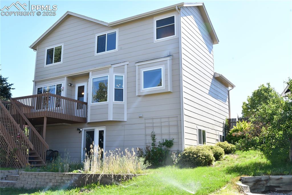 Image 43 of 48: Back of property featuring stairs and a wooden deck