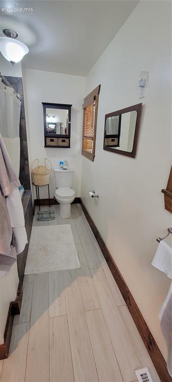Image 18 of 30: Full bathroom featuring light-toned plank flooring, a built-in bathtub with