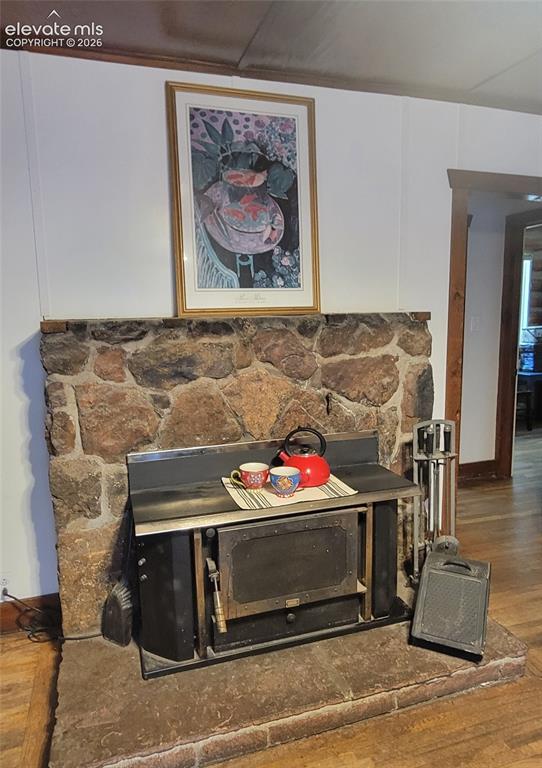 Image 6 of 30: Stone-faced fireplace with a wood-burning insert and an extended hearth