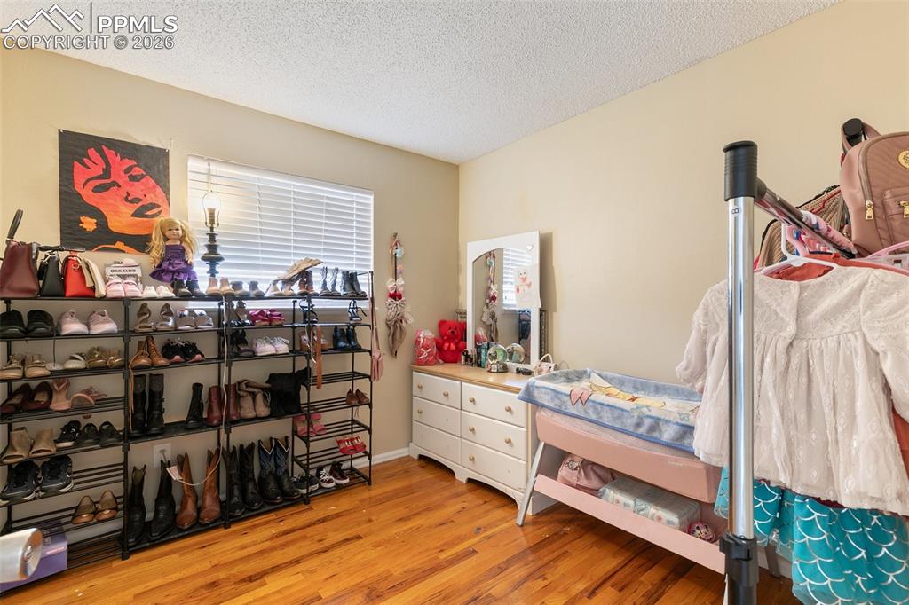 Image 17 of 29: Bedroom with light wood-style flooring and a textured ceiling