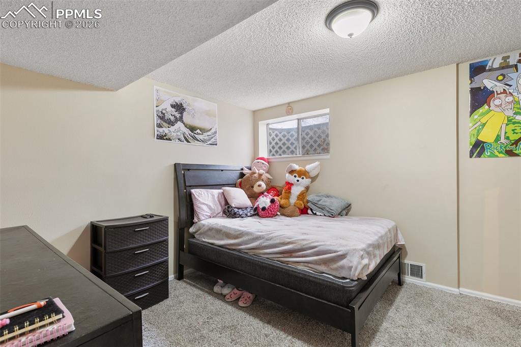 Image 22 of 29: Carpeted bedroom with a textured ceiling