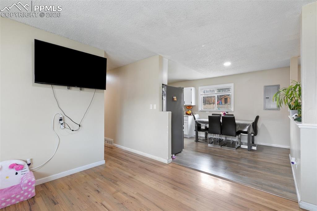 Image 5 of 29: Recreation room with a textured ceiling, light wood-style floors, electric 