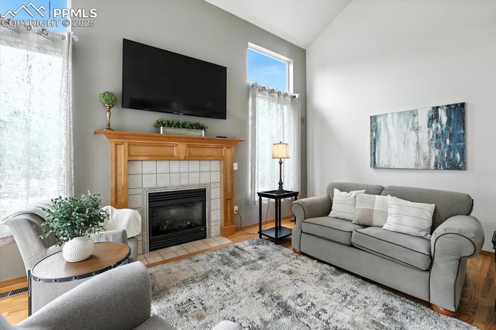 Image 14 of 41: Light and bright living with solid wood mantel and hardwood floors