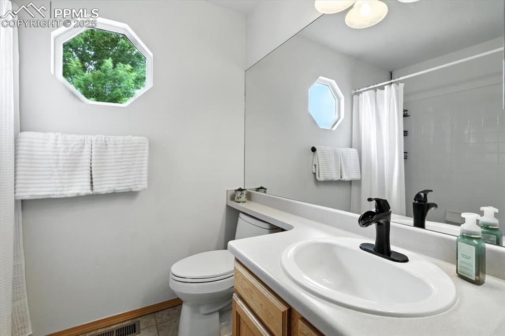 Image 23 of 41: Hall bath has west facing window and tile flooring