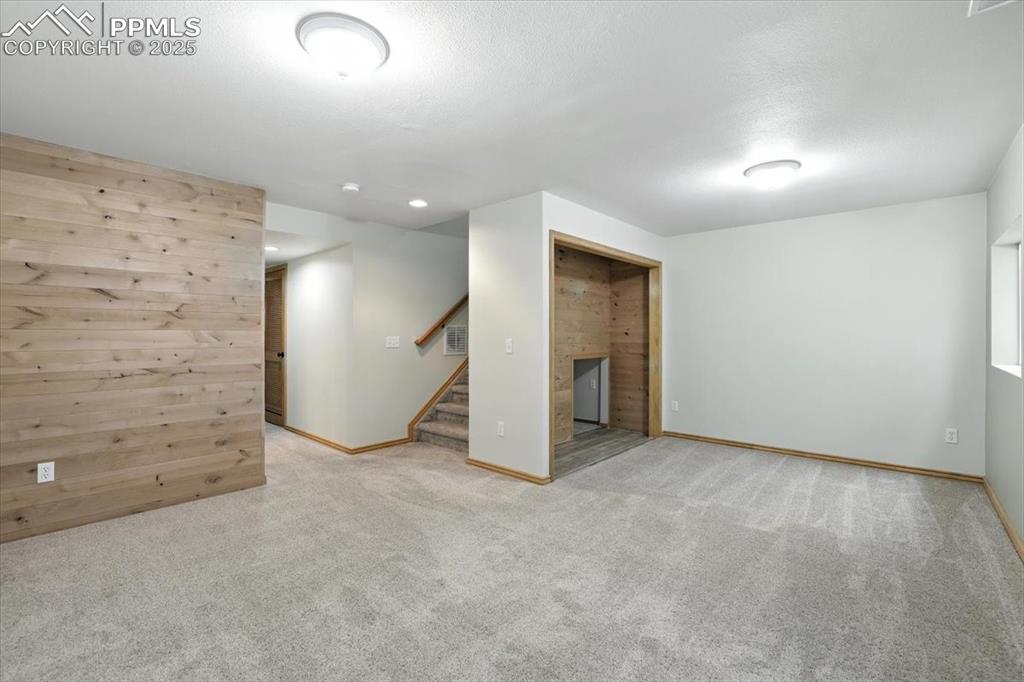 Image 26 of 41: Basement family room has skip troweled walls and updated trim