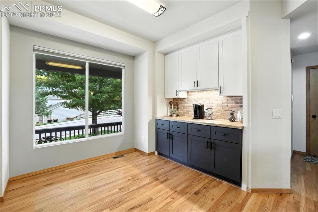 Image 6 of 41: Custom coffee bar with abundant cabinetry and butcher block countertop