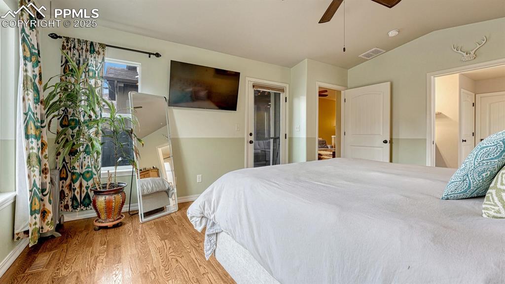 Image 16 of 44: Bedroom with light wood-style floors, vaulted ceiling, and ceiling fan