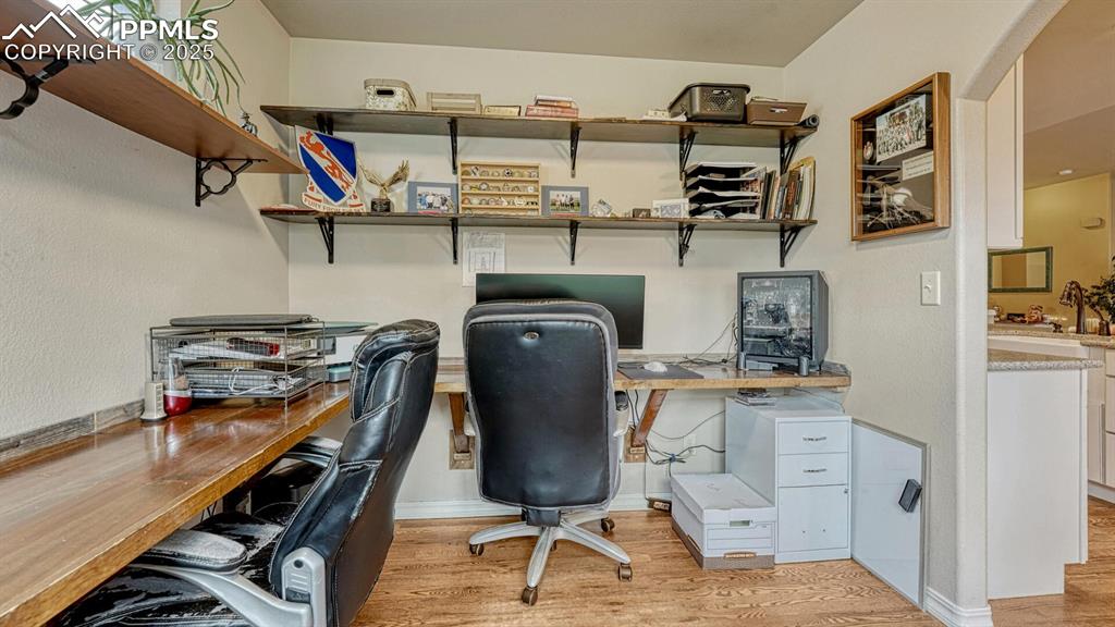 Image 20 of 44: Office space with light wood-type flooring and arched walkways