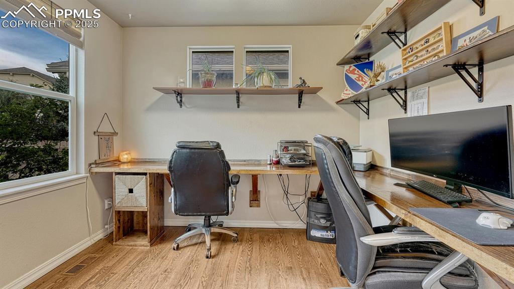 Image 29 of 44: Home office with light wood-style floors and healthy amount of natural ligh