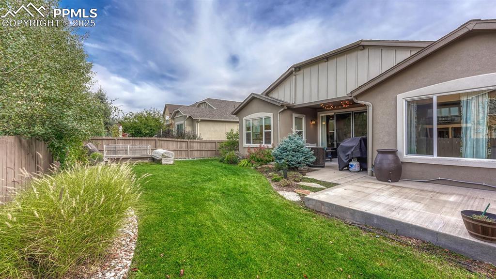 Image 43 of 44: Fenced backyard with a patio