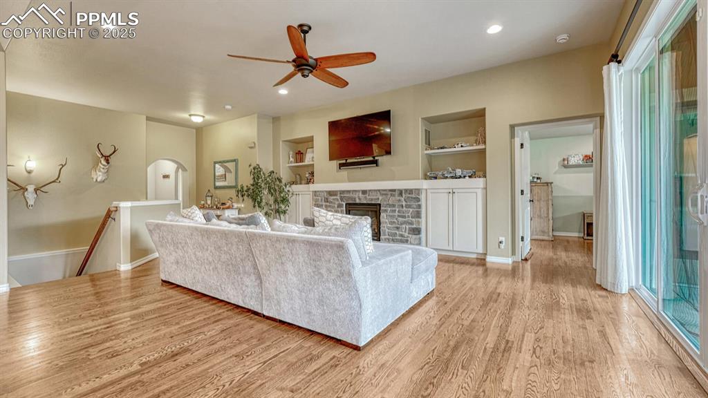 Image 7 of 44: Living area with built in shelves, light wood-style flooring, recessed ligh