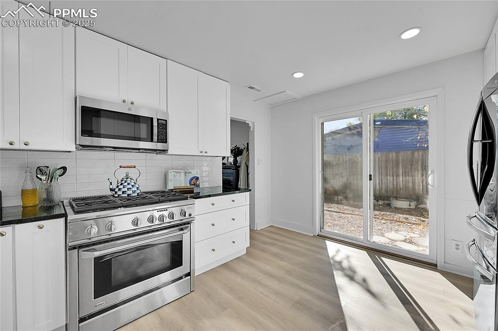 Image 14 of 47: Kitchen features dimmable recessed lighting and new luxury vinyl plank floo