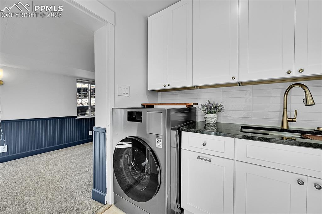 Image 16 of 47: View from kitchen into sunroom with wainscoted wall