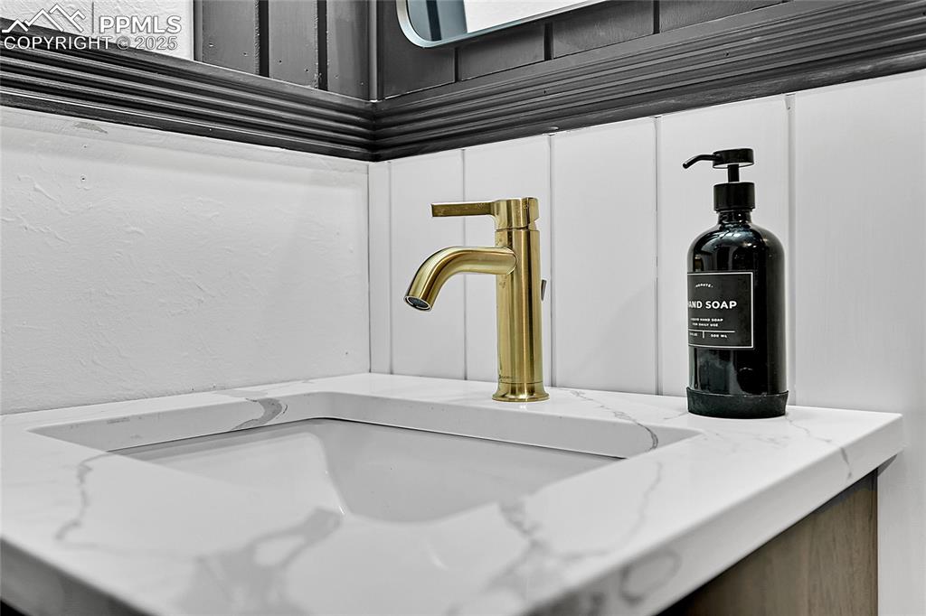 Image 24 of 47: Soft close vanity w/ quartz countertops and champagne bronze Delta faucet.