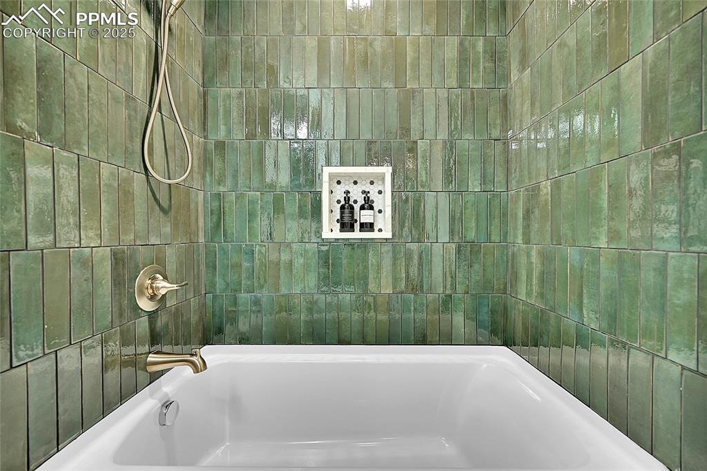 Image 25 of 47: Designer juniper green tile w/ built-in niche and champagne bronze Delta fi