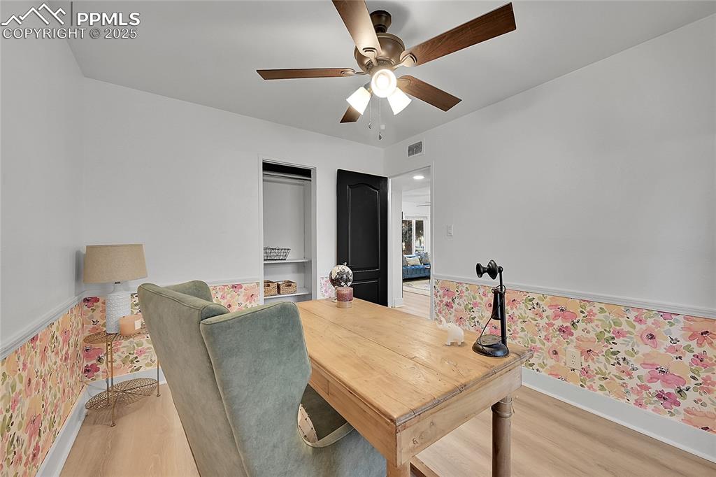 Image 27 of 47: Office space with wallpapered walls, new LVP flooring, wainscoting, and cei