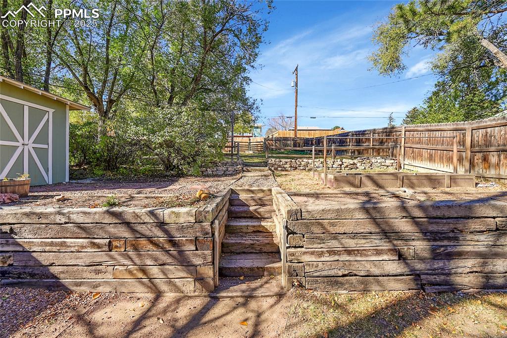 Image 29 of 47: Fully fenced backyard featuring a powered workshop.