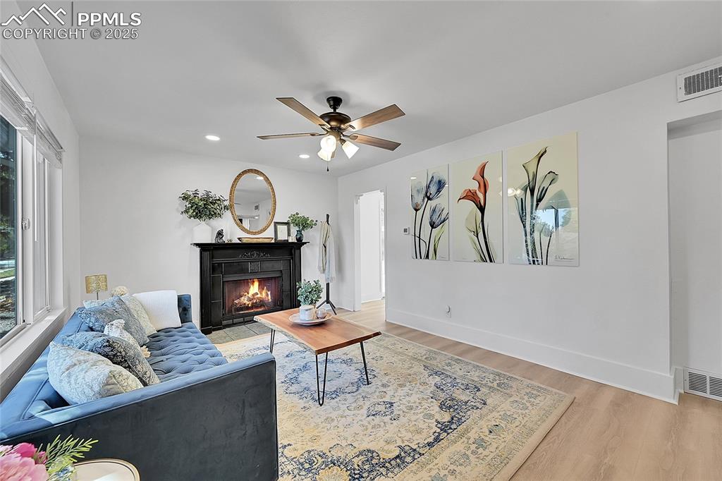 Image 5 of 47: Living area with new luxury vinyl planks, wood burning fireplace, dimmable 