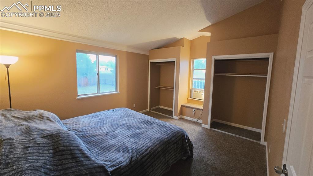 Image 17 of 42: Master bedroom featuring two closets, vaulted ceiling, and built in sitting