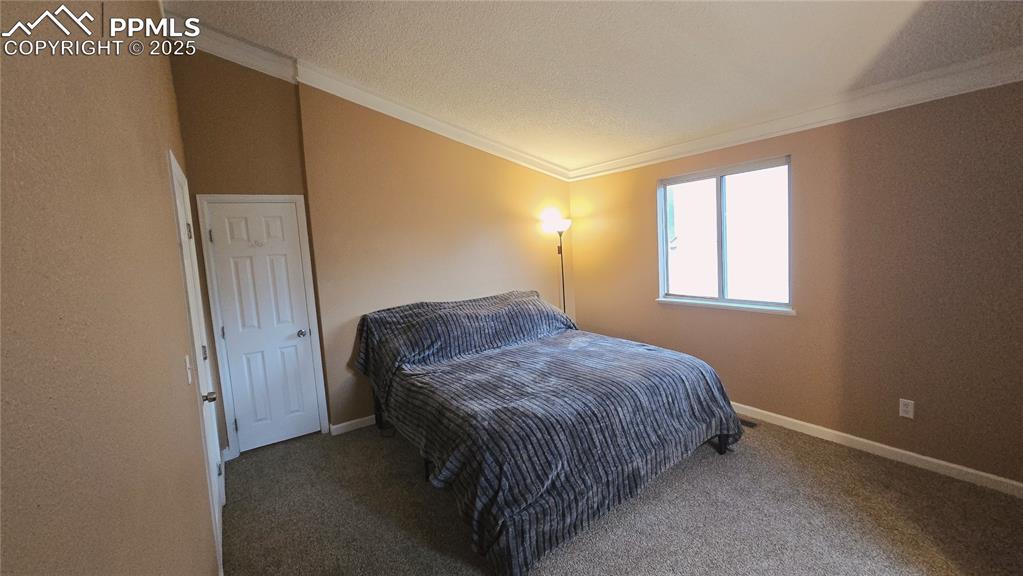 Image 18 of 42: Carpeted bedroom featuring ornamental molding and a textured ceiling