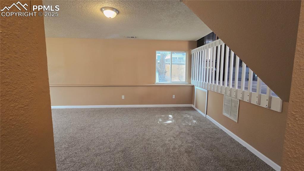 Image 29 of 42: Unfurnished room featuring carpet flooring, a textured ceiling, and a textu