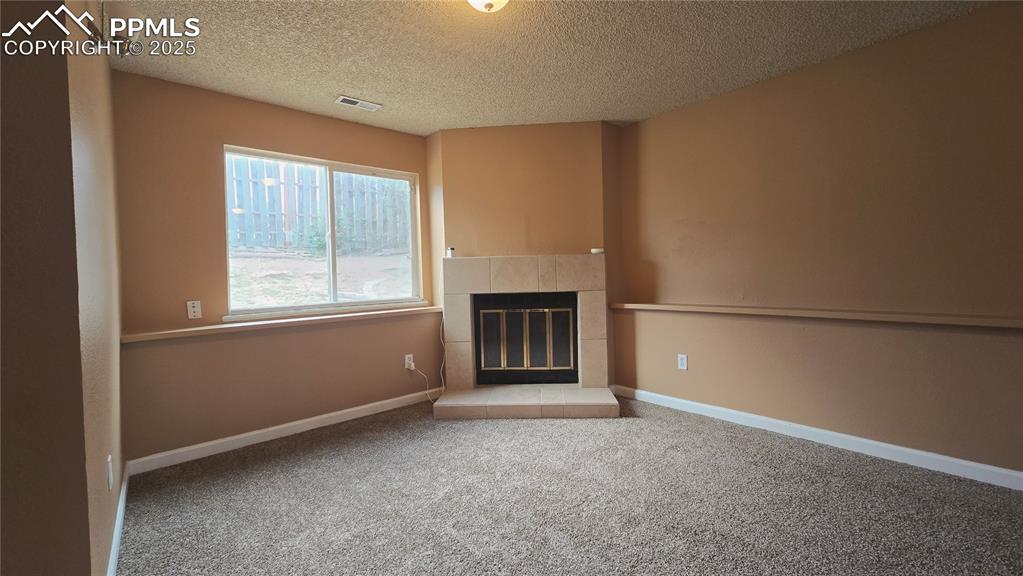 Image 31 of 42: Large recreation room with wood burning fire place.