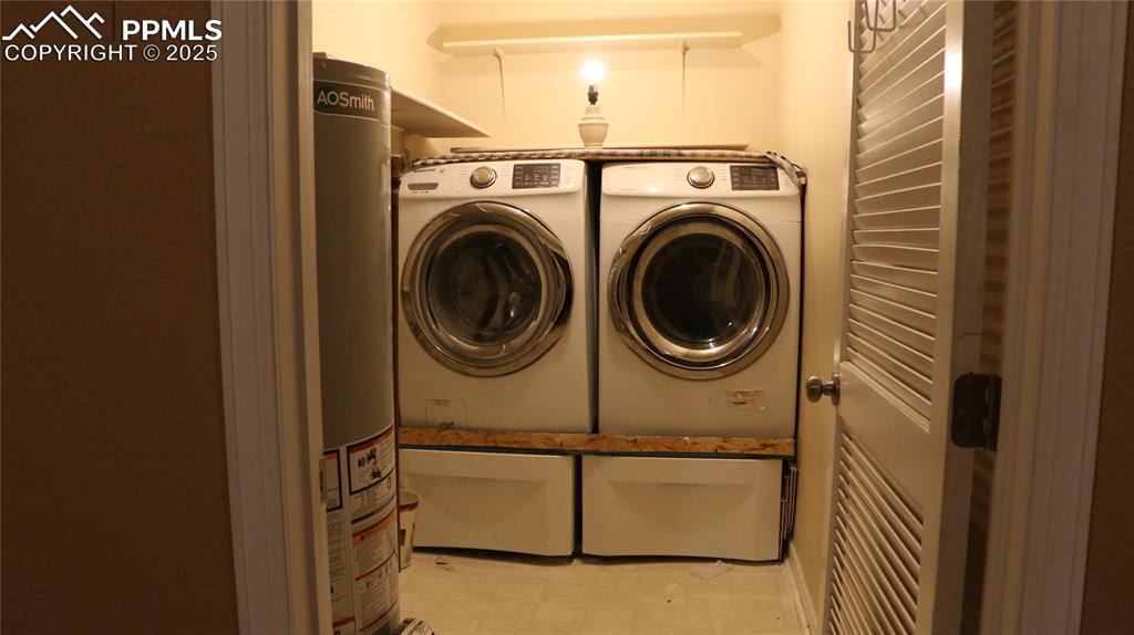 Image 33 of 42: Laundry area featuring gas water heater and washing machine and clothes dry