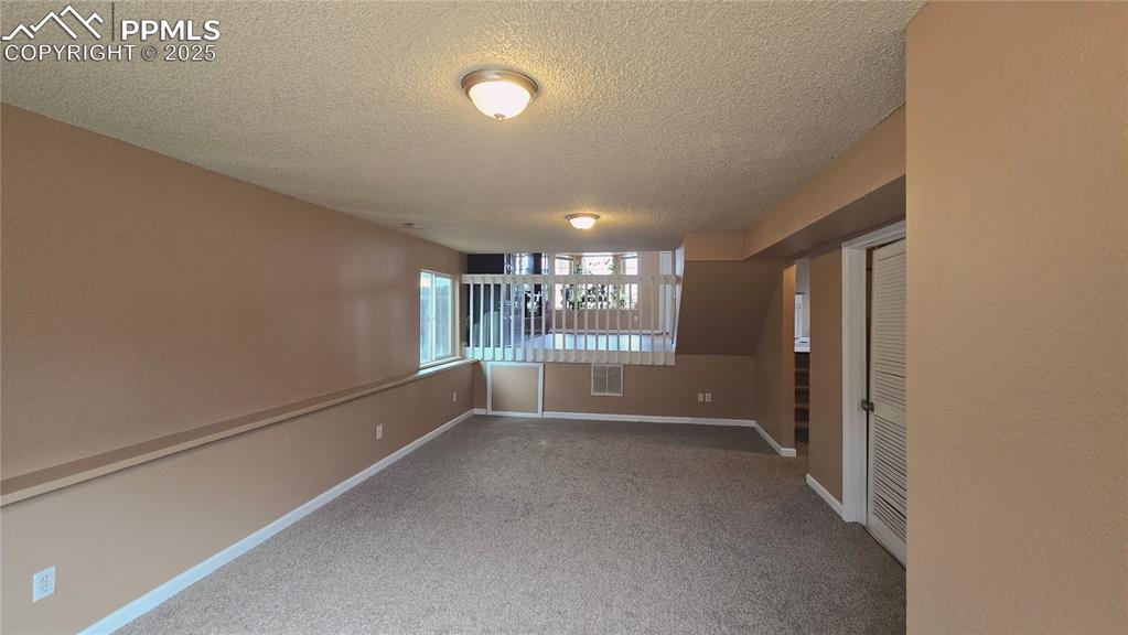 Image 34 of 42: Empty room featuring light carpet and a textured ceiling