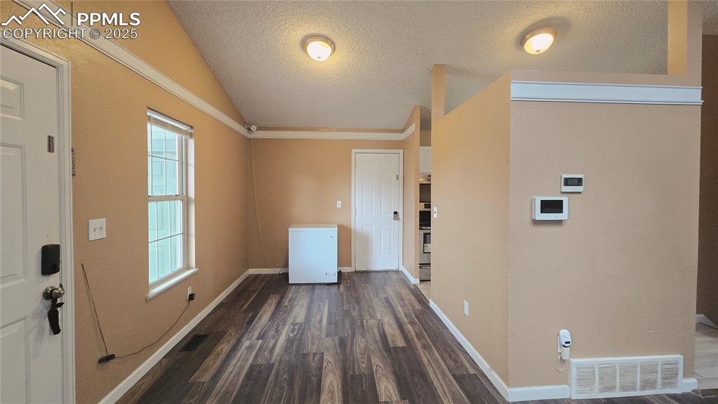 Image 5 of 42: Entrance foyer featuring a textured ceiling, dark wood finished floors, and