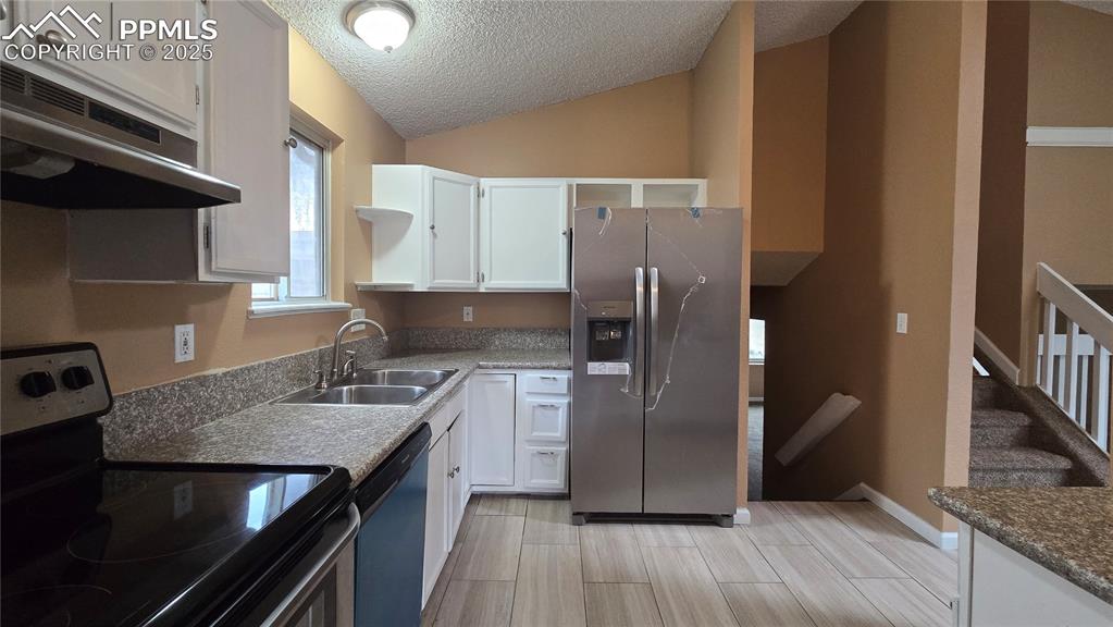 Image 8 of 42: Kitchen featuring appliances with stainless steel finishes, white cabinets,