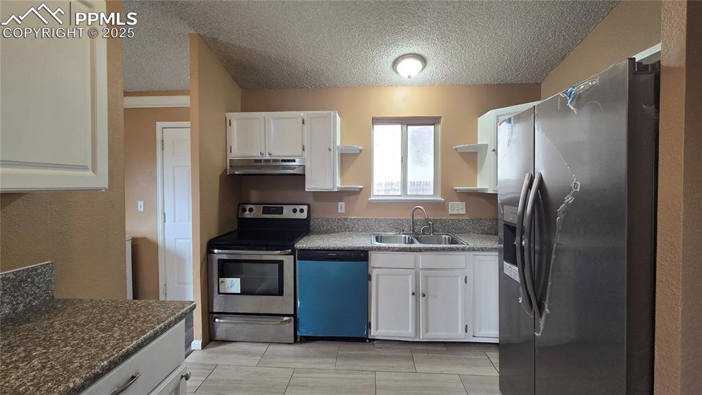Image 9 of 42: Kitchen with new dishwasher (still sealed in blue wrapping) and new refrige