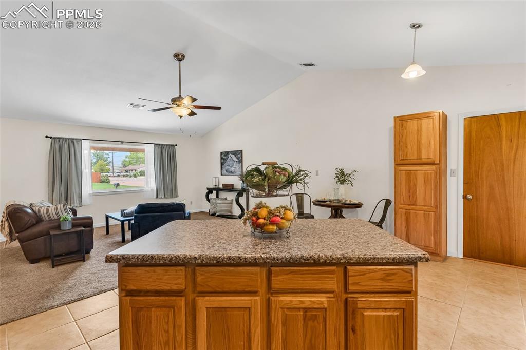 Image 14 of 42: Kitchen featuring a ceiling fan, light tile patterned flooring, lofted ceil