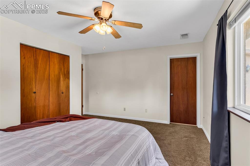 Image 20 of 42: Carpeted bedroom featuring multiple windows, a closet, baseboards, and ceil