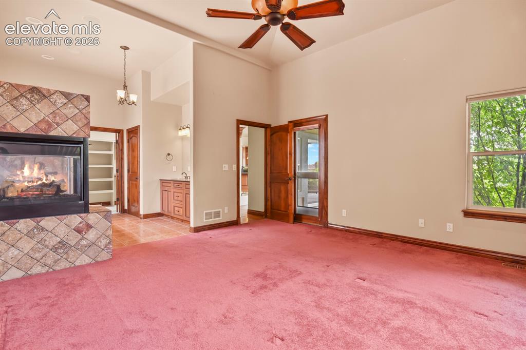 Image 17 of 33: Large primary suite with private walk out with two sided gas fireplace