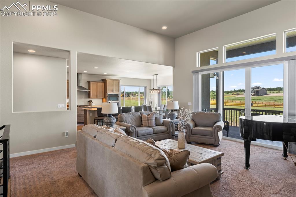 Image 10 of 50: Living room featuring carpet flooring, a towering ceiling, and recessed lig