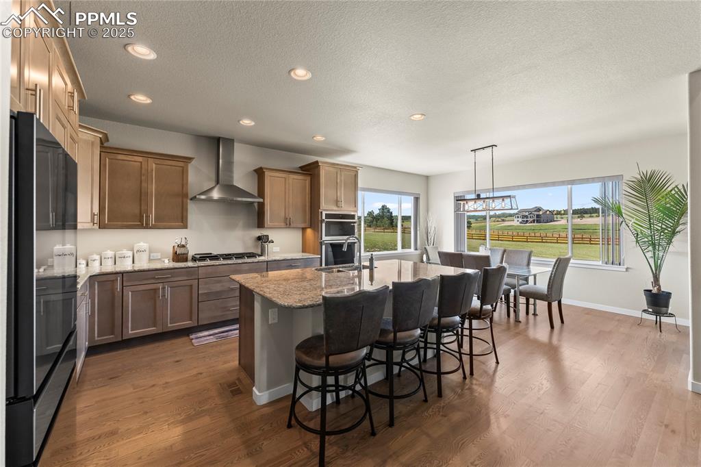 Image 14 of 50: Kitchen featuring appliances with stainless steel finishes, wall chimney ex