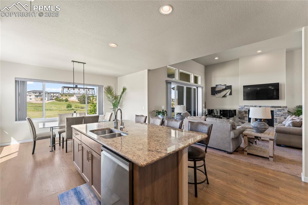 Image 16 of 50: Kitchen featuring stainless steel dishwasher, a kitchen island with sink, a