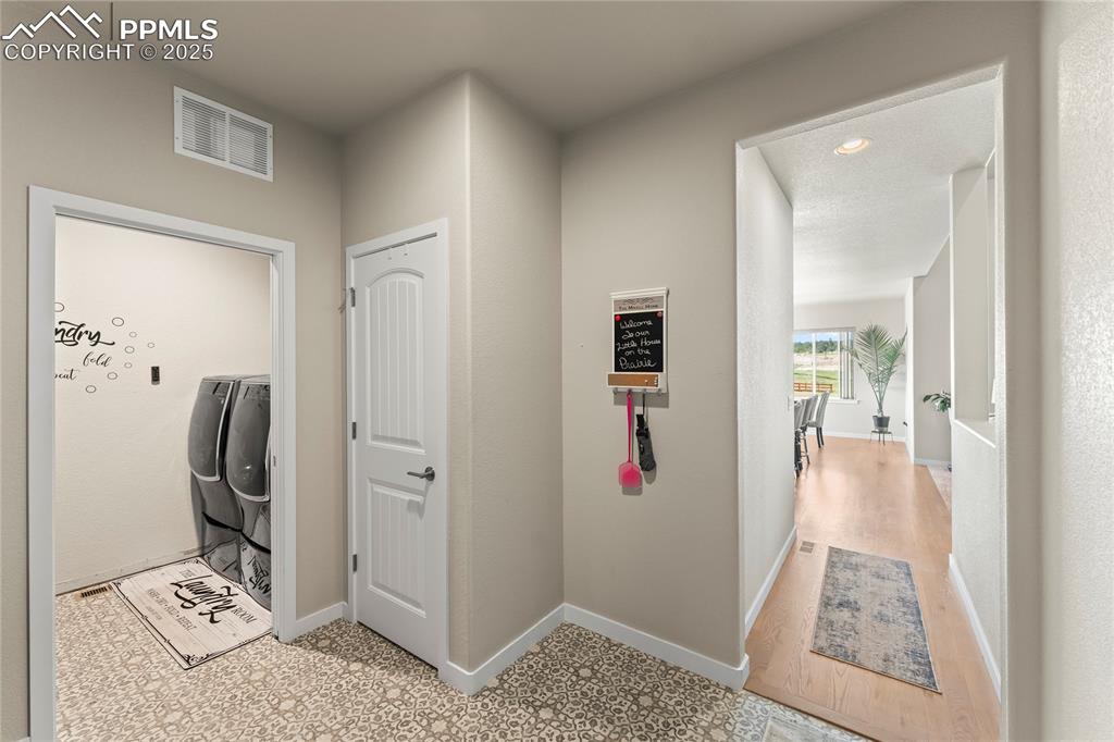 Image 21 of 50: Laundry area featuring washer and clothes dryer and baseboards