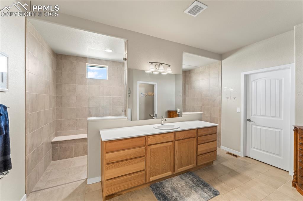 Image 27 of 50: Full bath featuring vanity, walk in shower, and tile patterned flooring