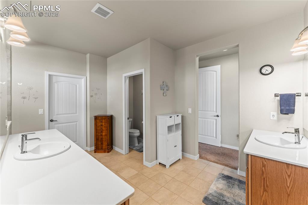 Image 28 of 50: Full bath featuring two vanities and tile patterned floors