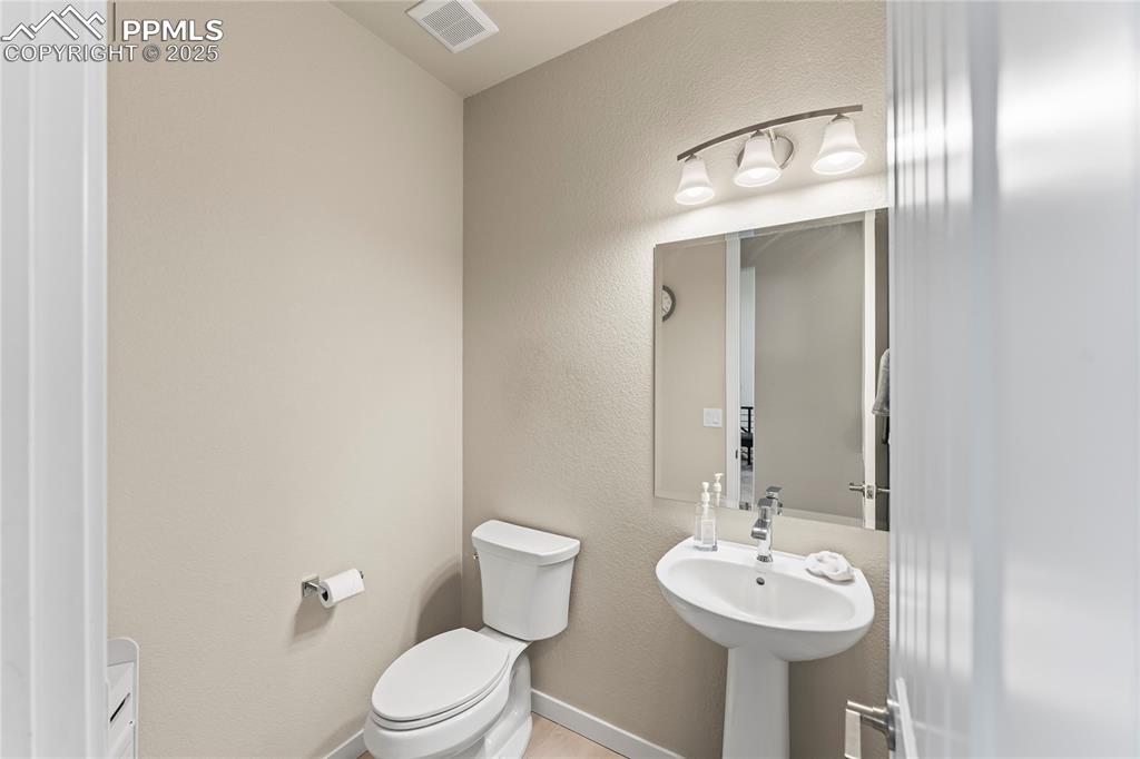 Image 31 of 50: Half bathroom with toilet and baseboards