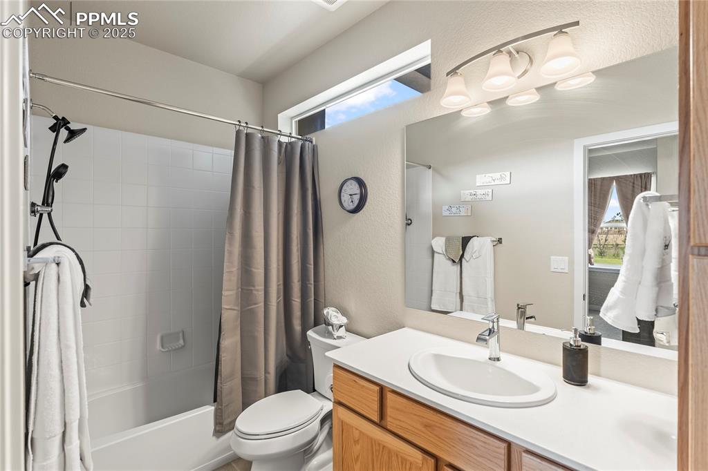 Image 35 of 50: Bathroom with vanity, shower / tub combo with curtain, plenty of natural li