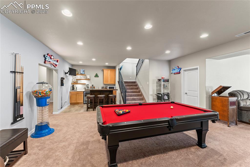 Image 37 of 50: Game room featuring bar area, light carpet, recessed lighting, pool table,