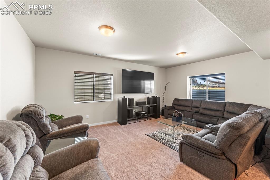 Image 40 of 50: Living area with light colored carpet and baseboards