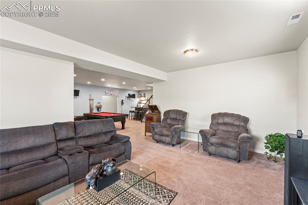 Image 42 of 50: Living room featuring billiards, light carpet, stairs, and recessed lightin