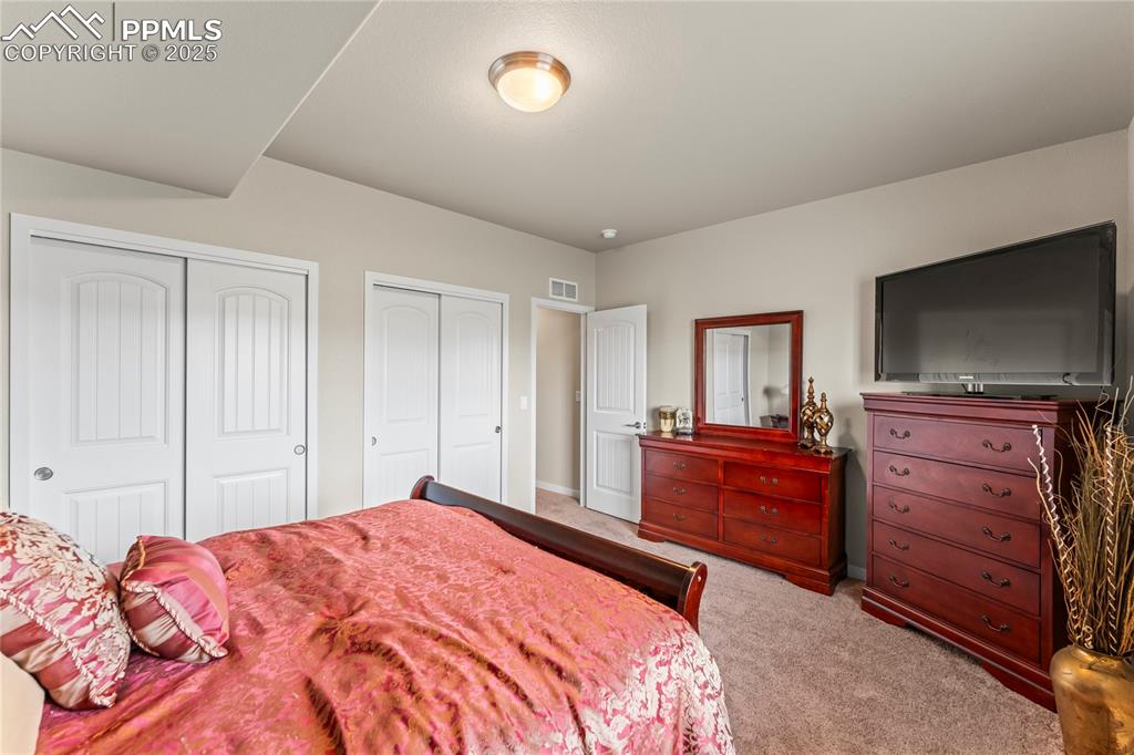 Image 48 of 50: Carpeted bedroom featuring two closets and baseboards