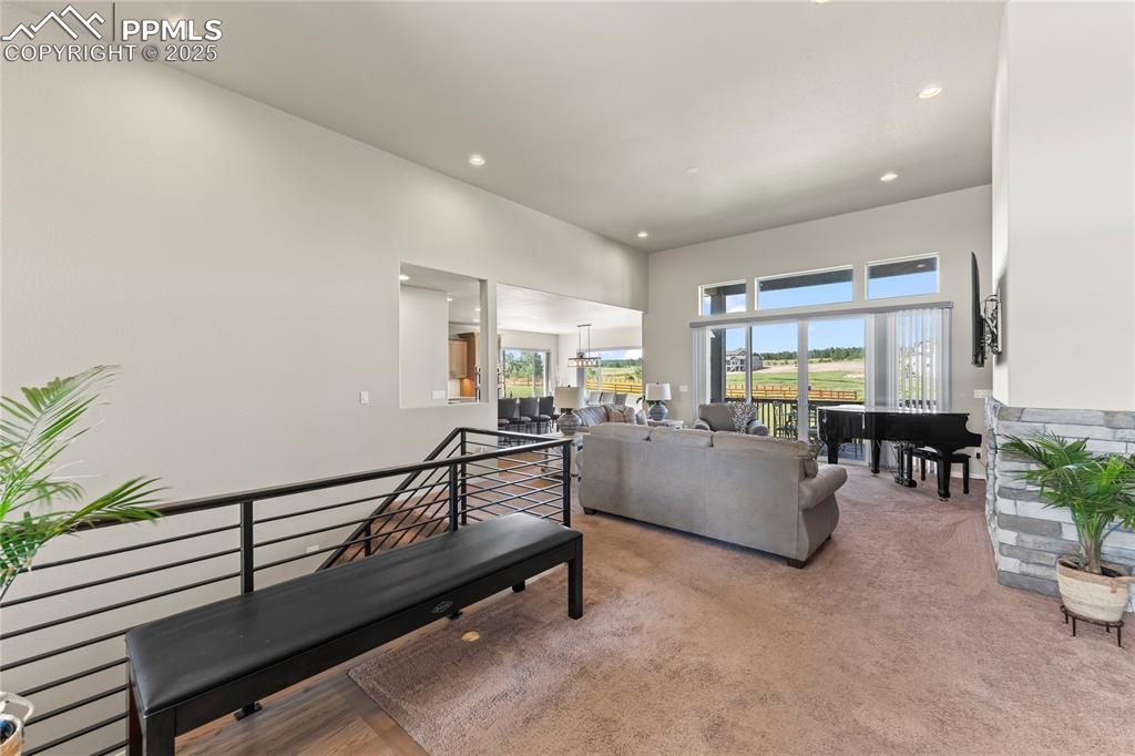 Image 8 of 50: Living room featuring recessed lighting, a high ceiling, and light colored